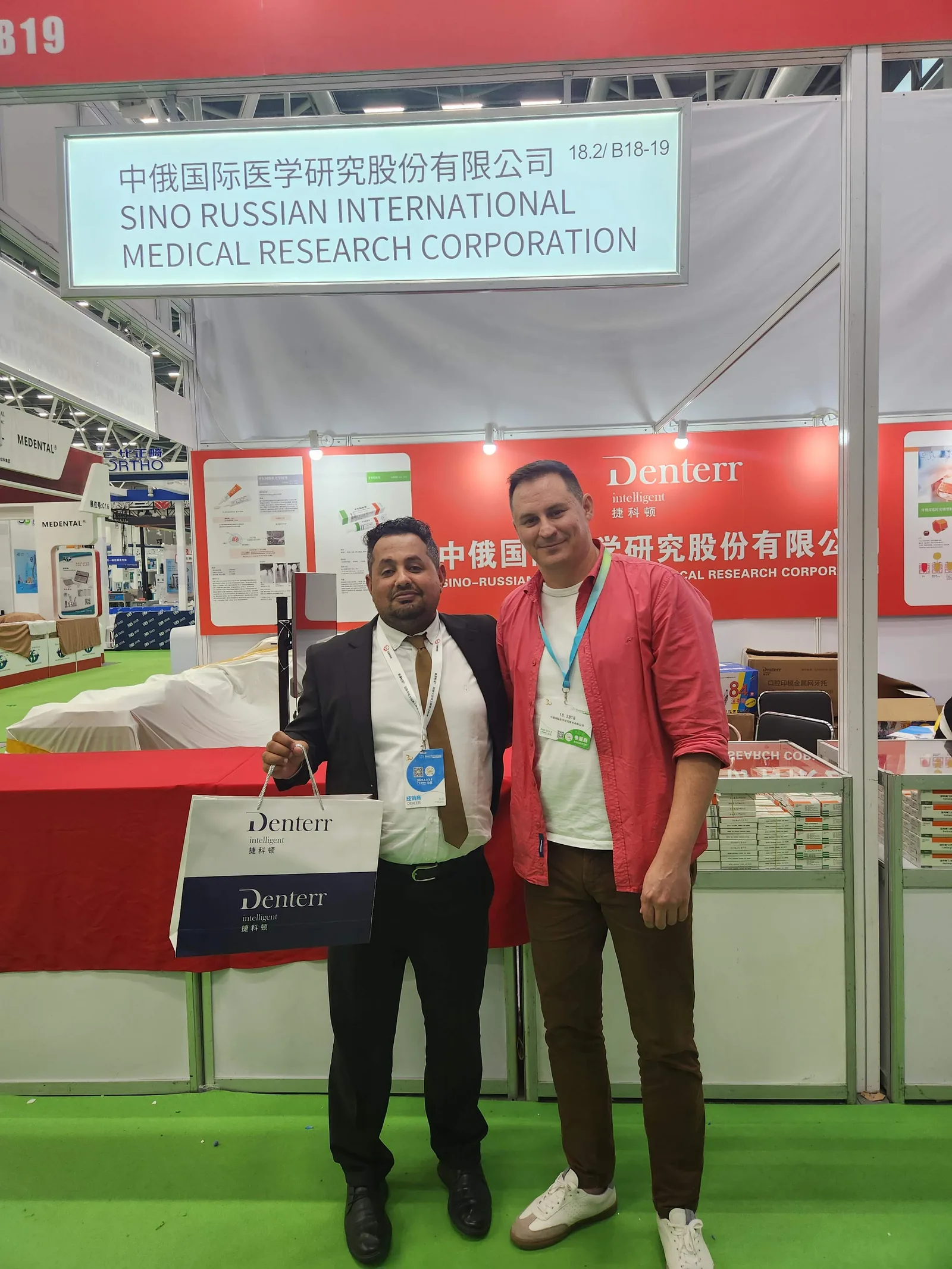 Два участника у стенда Shanghai International Smile Corporation